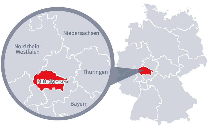 Diese Grafik zeigt eine Karte von Deutschland mit einer detaillierten Ansicht der Region Mittelhessen. Mittelhessen ist in Rot hervorgehoben und liegt im westlichen Teil Deutschlands. Ein Lupensymbol vergrößert diesen Bereich, um die Lage genauer darzustellen. 